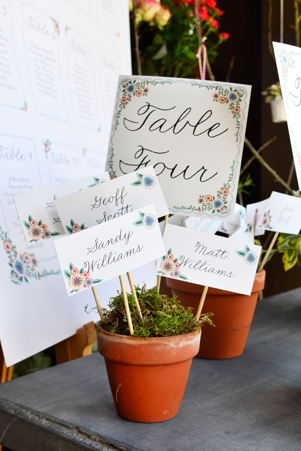 wedding seating plan using terracotta flower pots and moss