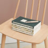 stack of book review journals dark green cover on chair