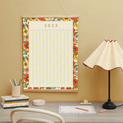 a styled image of a 2024 year planner over a desk with pretty stationery elements on it and a desk lamp there is a earthy yellow wall in the background