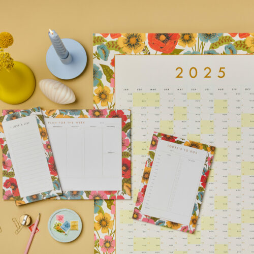 Bloom floral stationery collection of 2025 year planner plus planner notepads. Poppy like flowers are in red, pink, yellow and blue. Styled on Hay Farrow and ball background